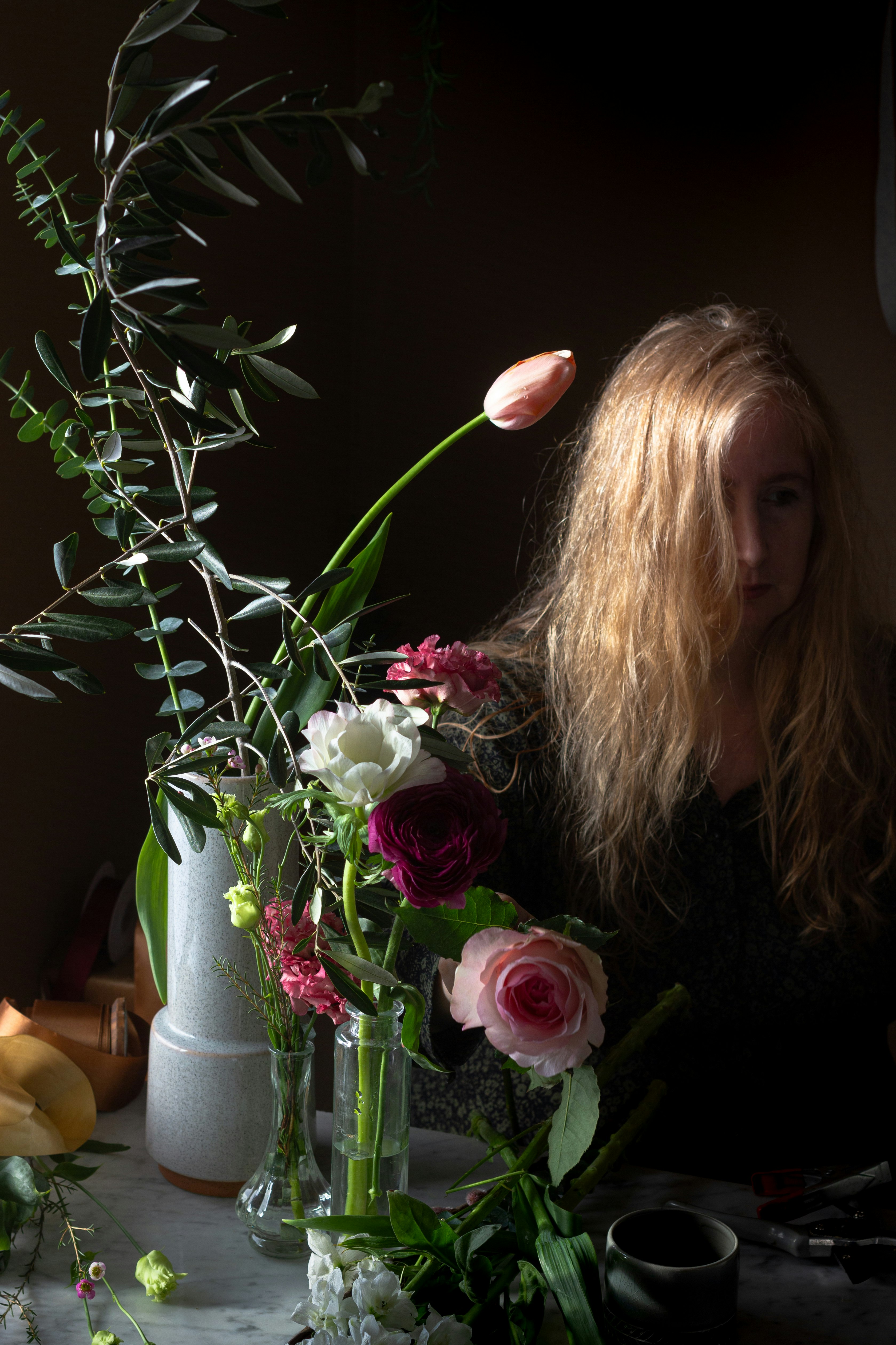 woman in black shirt holding pink rose bouquet